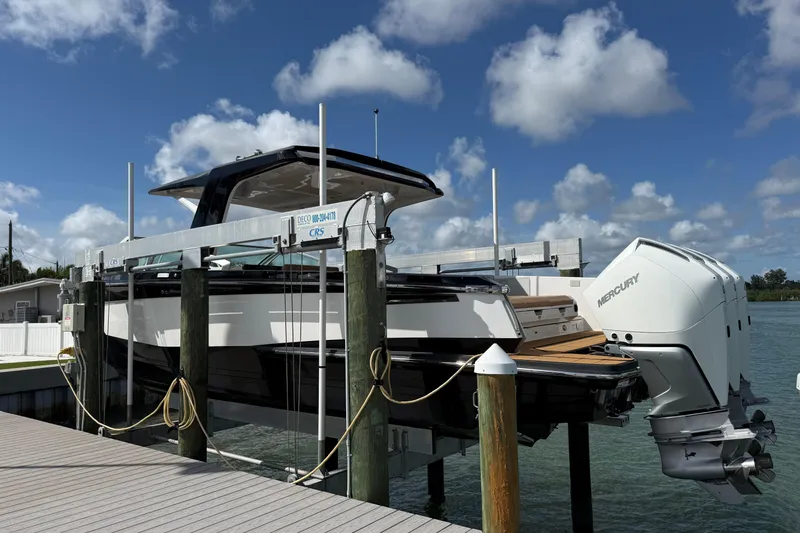 Slide: The Image of 2023 Aviara AV36 OB boat docked with Mercury outboard engines under a clear sky. - 10