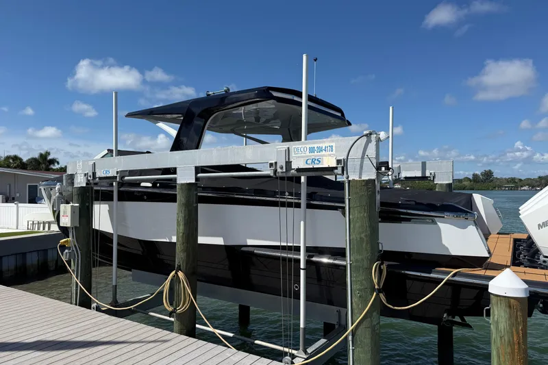 Slide: The Image of 2023 Aviara AV36 OB boat on lift at dock under clear blue sky. - 11