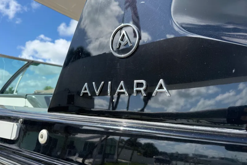 Slide: The Image of 2023 Aviara AV36 OB boat logo with sleek black finish under blue sky. - 13