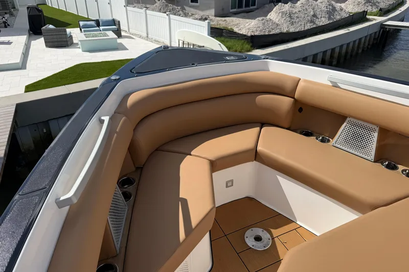 Slide: The Image of Luxurious seating area on 2023 Aviara AV36 OB boat, featuring tan upholstery and cup holders. - 14