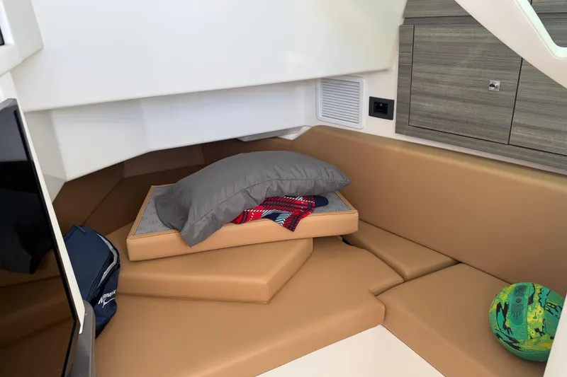 Slide: The Image of 2023 Aviara AV36 OB cabin interior with tan seating, pillow, and colorful ball. - 31