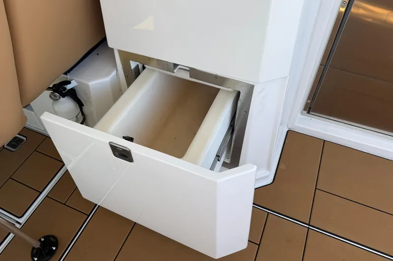 Slide: The Image of An open compartment on a boat with a fire extinguisher beside it. - 38