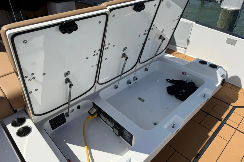 Slide: The Image of 2023 Aviara AV36 OB boat storage compartment with open hatches and utility connections. - 46