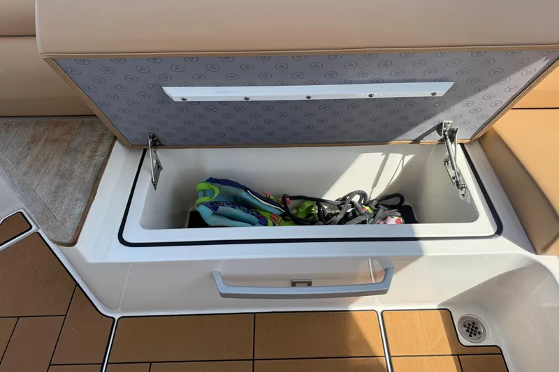 Slide: The Image of Open storage compartment on 2023 Aviara AV36 OB boat, containing colorful gear. - 49