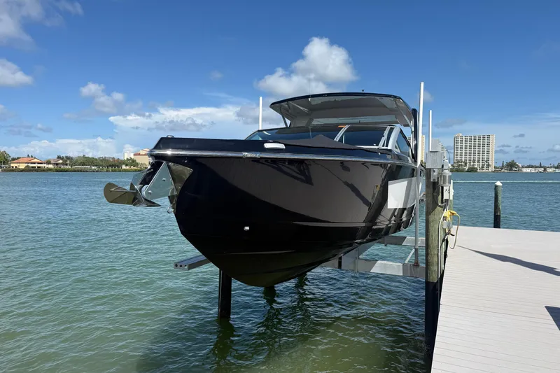 Slide: The Image of 2023 Aviara AV36 OB boat docked on a lift, with a scenic waterfront backdrop. - 7
