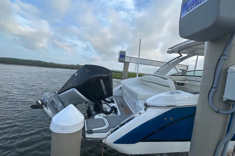 Slide: The Image of 2021 Cobalt 30SC boat docked, featuring a Mercury outboard motor, under a partly cloudy sky. - 3
