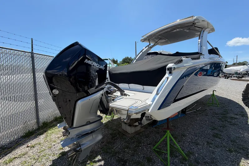 Slide: The Image of 2021 Cobalt 30SC boat with Mercury outboard engine, parked on gravel lot. - 5
