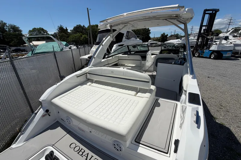 Slide: The Image of 2021 Cobalt 30SC boat with spacious seating and sleek design, docked outdoors. - 9
