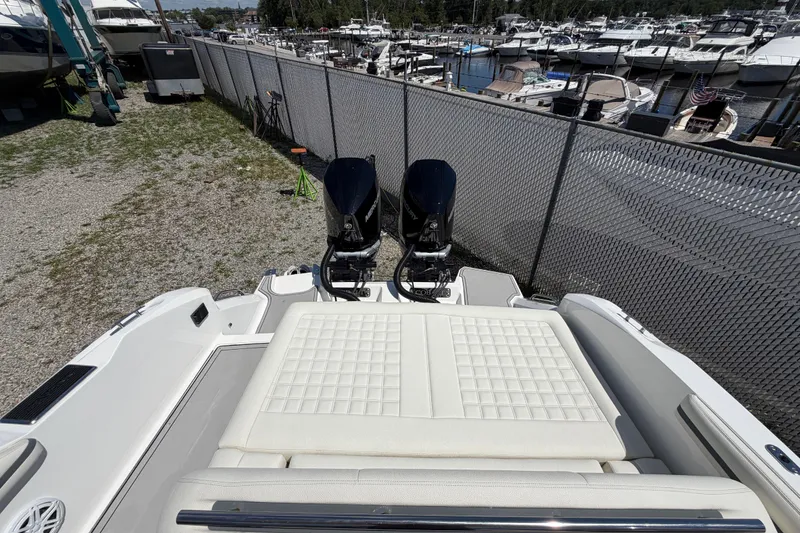 Slide: The Image of 2021 Cobalt 30SC boat with dual engines, docked near a marina. - 18