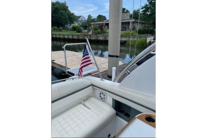Slide: The Image of 2021 Cobalt 30SC boat docked, featuring American flag and luxurious seating. - 6