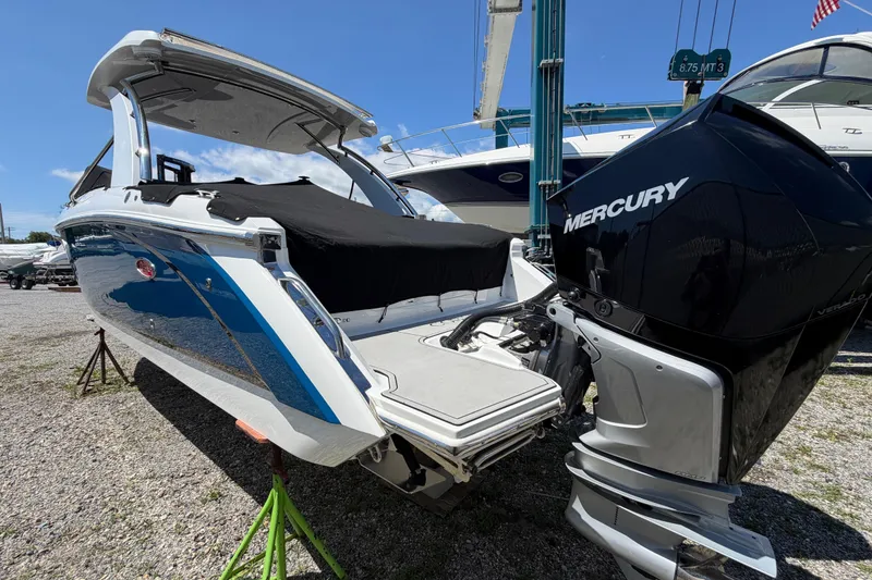 Slide: The Image of 2021 Cobalt 30SC boat with Mercury engine, parked on gravel under a clear sky. - 4