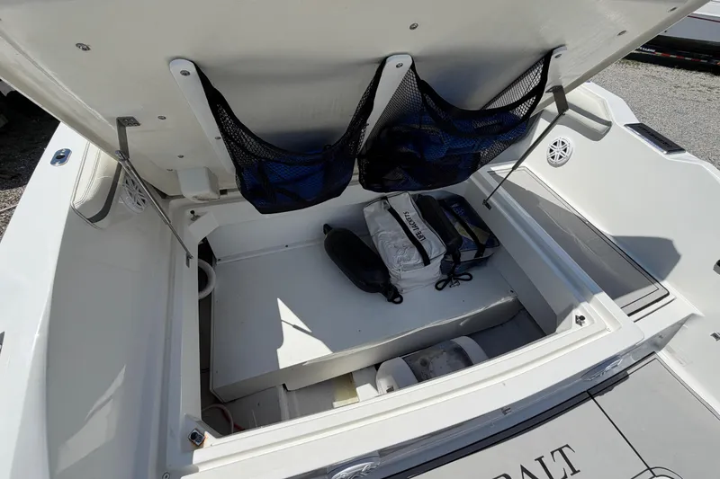 Slide: The Image of Open storage compartment in 2021 Cobalt 30SC boat, featuring organized gear and equipment. - 11