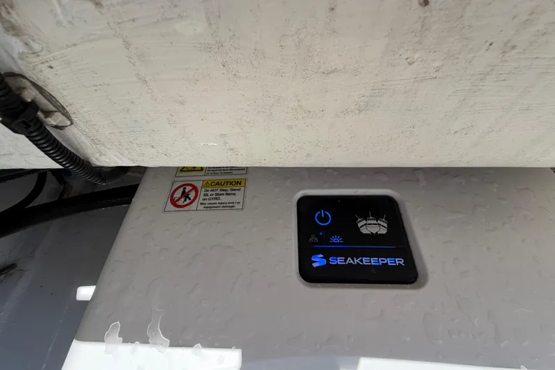 Slide: The Image of Seakeeper control panel on 2021 Cobalt 30SC boat, featuring caution label and wiring. - 13