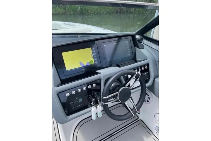 Slide: The Image of 2021 Cobalt 30SC boat dashboard with dual screens and steering wheel. - 8