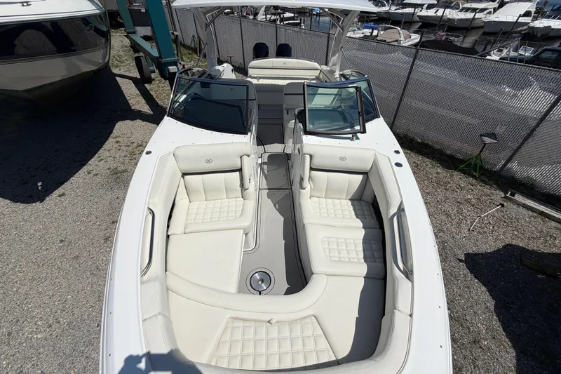 Slide: The Image of 2021 Cobalt 30SC boat with white leather seating, docked near other boats. - 38