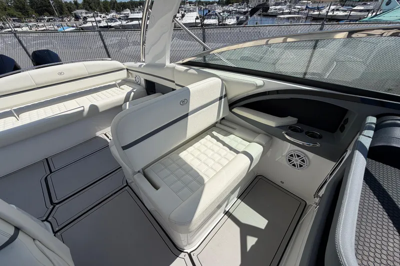 Slide: The Image of 2021 Cobalt 30SC boat interior with white seating and cup holders, docked at marina. - 32