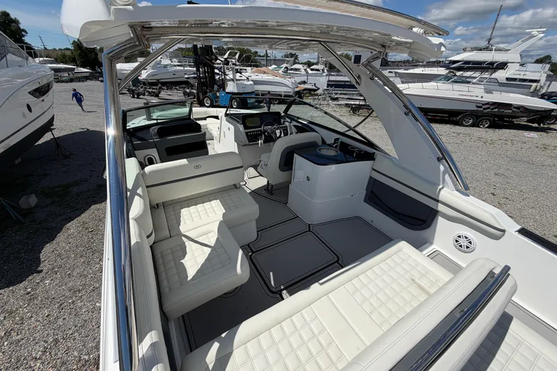 Slide: The Image of 2021 Cobalt 30SC boat interior with white seating, docked among other boats. - 16