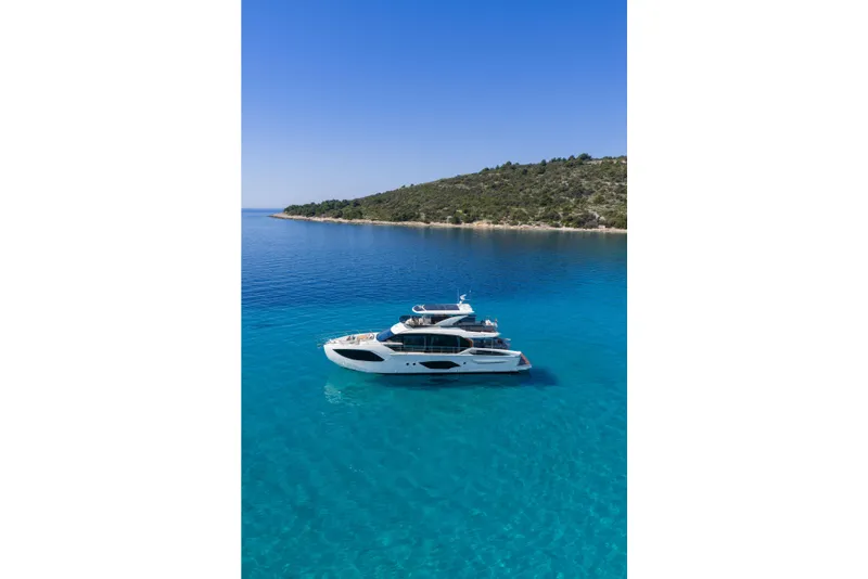 Slide: The Image of Luxury Absolute 70 Fly yacht cruising in clear blue waters, 2027 model. - 15