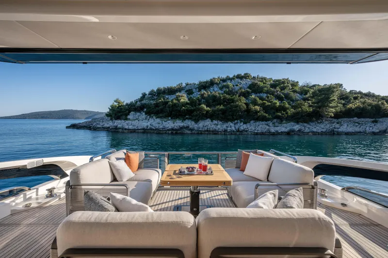 Slide: The Image of Luxurious Absolute 70 Fly yacht deck with elegant seating, overlooking serene waters and lush island, 2027 model. - 19