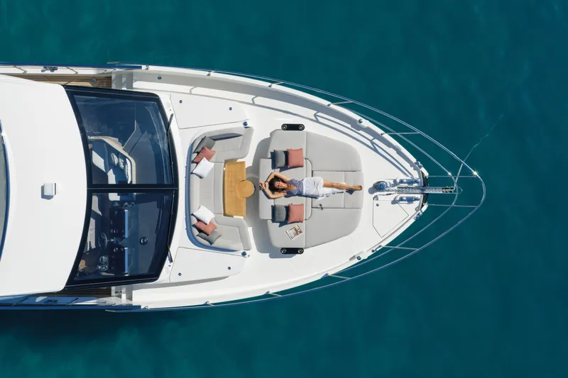 Slide: The Image of Aerial view of a 2027 Absolute 70 Fly yacht with a person relaxing on deck. - 24