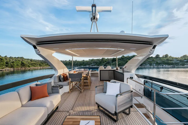 Slide: The Image of Luxurious 2027 Absolute 70 Fly yacht deck with elegant seating and scenic water view. - 26