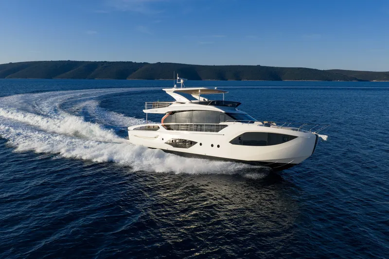 Slide: The Image of Luxurious 2027 Absolute 70 Fly yacht cruising on open sea under clear blue sky. - 6