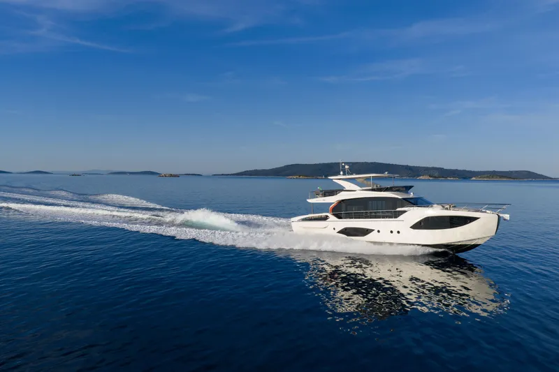 Slide: The Image of 2027 Absolute 70 Fly yacht cruising on calm blue waters under clear skies. - 8