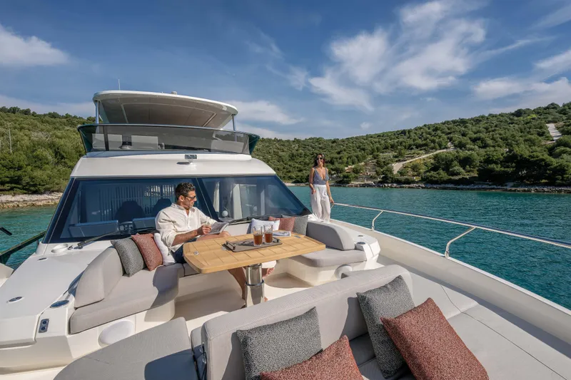 Slide: The Image of A luxurious boat with people relaxing on deck, surrounded by clear water and green hills. - 15