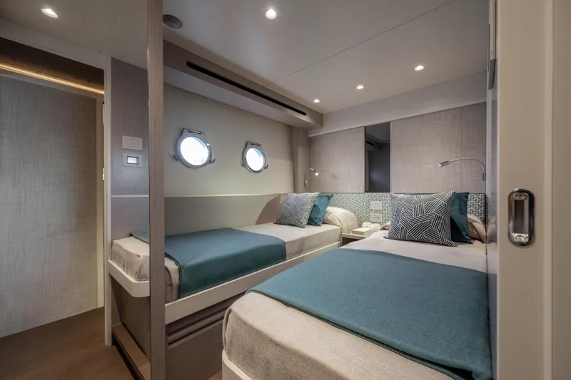 Slide: The Image of Elegant bedroom on a yacht with two single beds and porthole windows. - 38