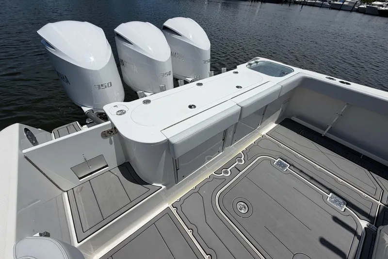 Slide: The Image of 2009 Everglades 350LX boat with triple Yamaha 350 engines, docked on calm water. - 14