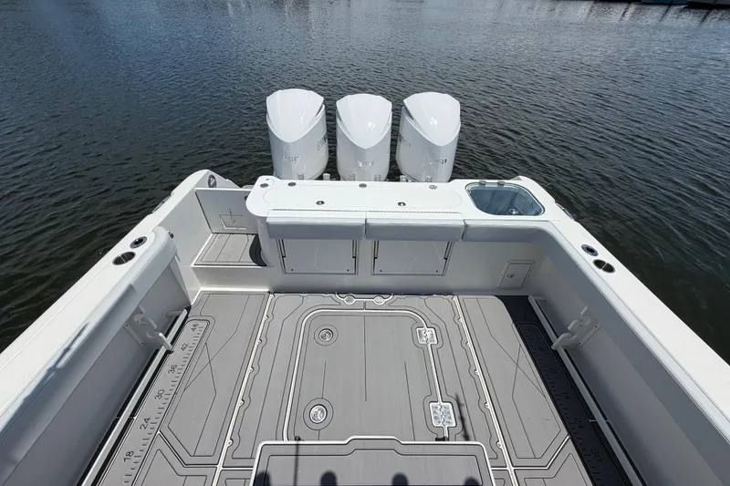 Slide: The Image of 2009 Everglades 350LX boat deck with triple engines on calm water. - 16