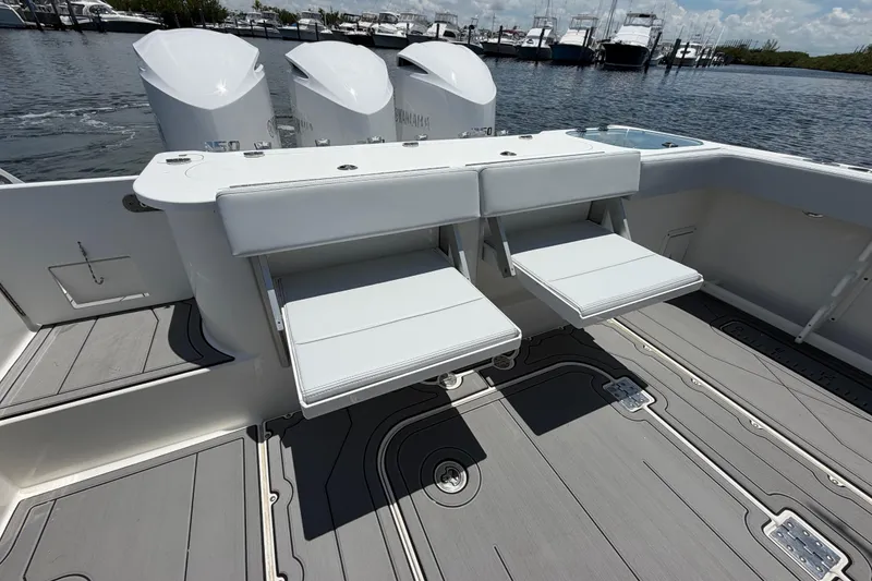 Slide: The Image of 2009 Everglades 350LX boat with foldable seats and triple outboard engines, docked at marina. - 17