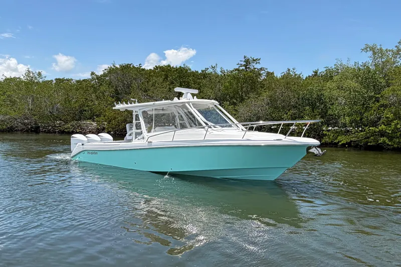Slide: The Image of 2009 Everglades 350LX boat cruising on a calm river under a clear blue sky. - 2