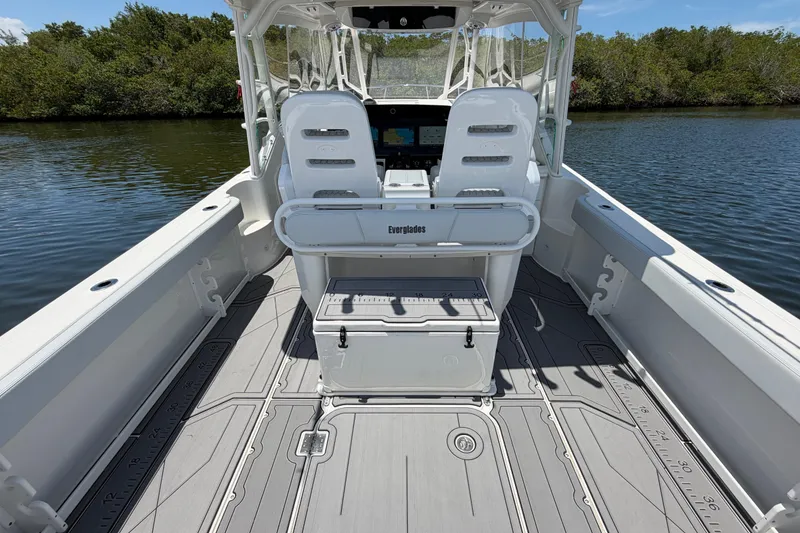Slide: The Image of 2009 Everglades 350LX boat interior with seating and storage, on calm water. - 23