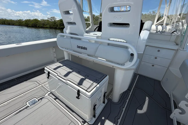 Slide: The Image of 2009 Everglades 350LX boat interior with seating and storage, docked by a scenic waterway. - 24