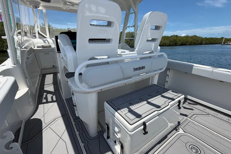 Slide: The Image of 2009 Everglades 350LX boat interior with seating and storage, docked by a scenic waterway. - 26