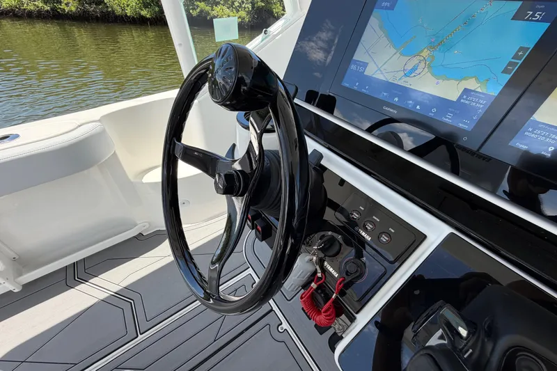 Slide: The Image of Steering wheel and navigation system of 2009 Everglades 350LX boat, featuring Garmin display. - 35