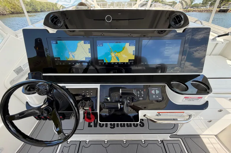 Slide: The Image of 2009 Everglades 350LX boat dashboard with dual navigation screens and steering wheel. - 37