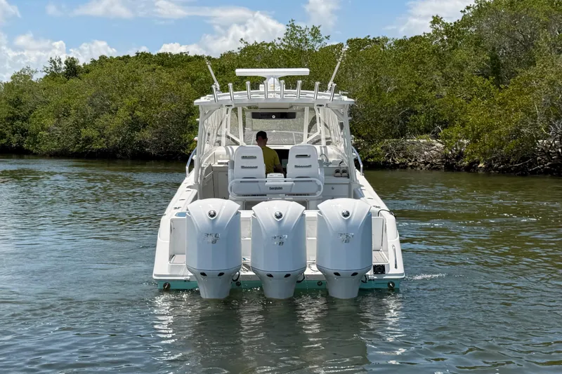 Slide: The Image of 2009 Everglades 350LX boat with triple engines cruising in a scenic waterway. - 4