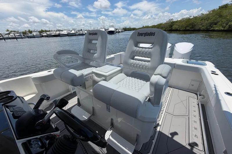 Slide: The Image of 2009 Everglades 350LX boat interior with plush seating and scenic marina backdrop. - 40