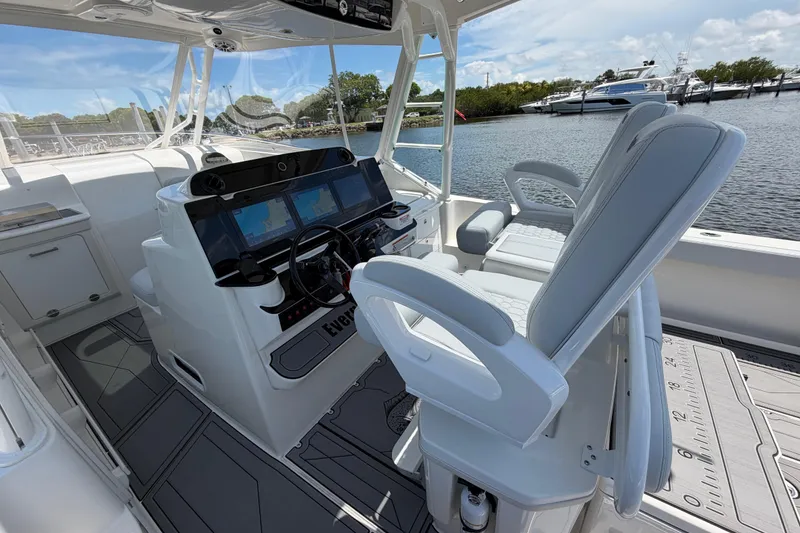 Slide: The Image of 2009 Everglades 350LX boat interior with helm, navigation screens, and seating by the water. - 41