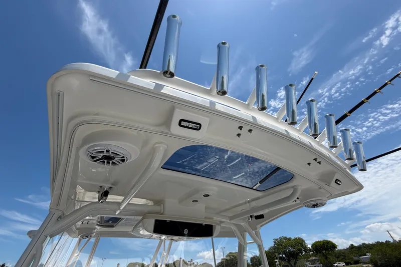 Slide: The Image of 2009 Everglades 350LX boat roof with rod holders and speakers under a clear blue sky. - 42