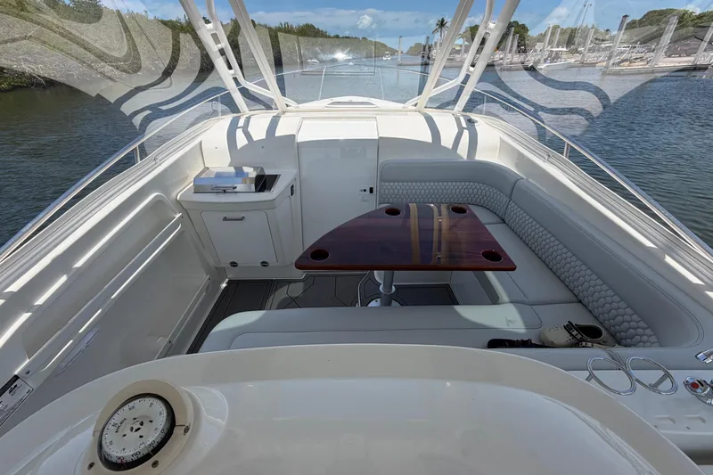 Slide: The Image of 2009 Everglades 350LX boat interior with seating and table, docked in a marina. - 43