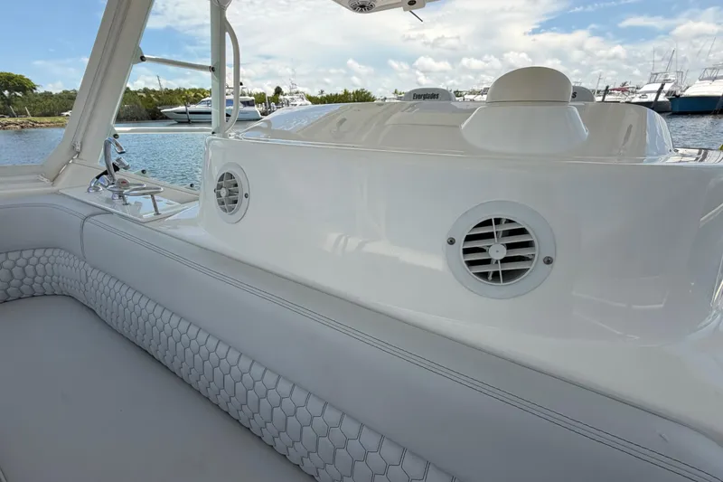 Slide: The Image of 2009 Everglades 350LX boat interior with white seating and speaker, docked by the water. - 49