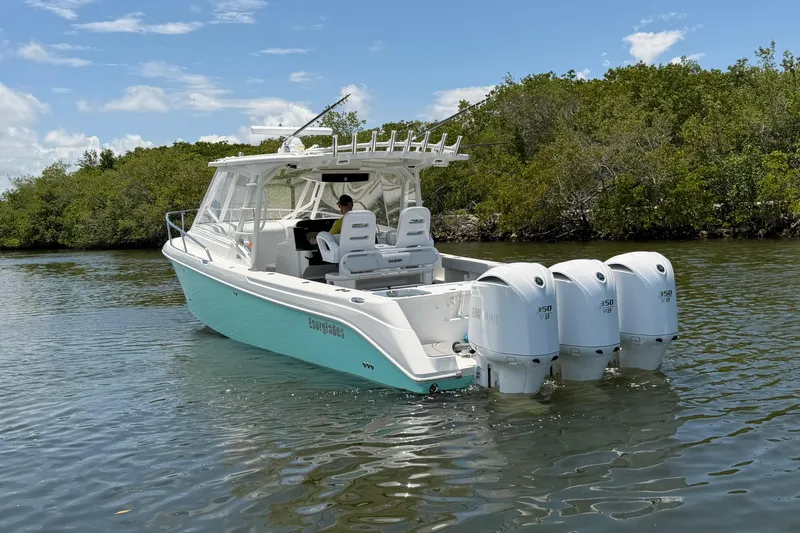Slide: The Image of 2009 Everglades 350LX boat with triple Yamaha engines on a calm waterway. - 5