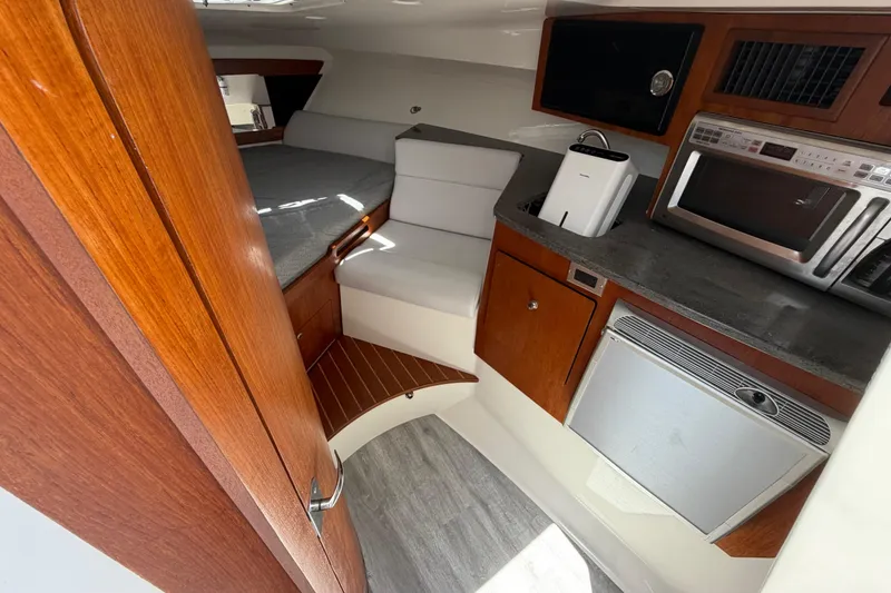 Slide: The Image of Interior of 2009 Everglades 350LX boat with kitchenette and seating area. - 53