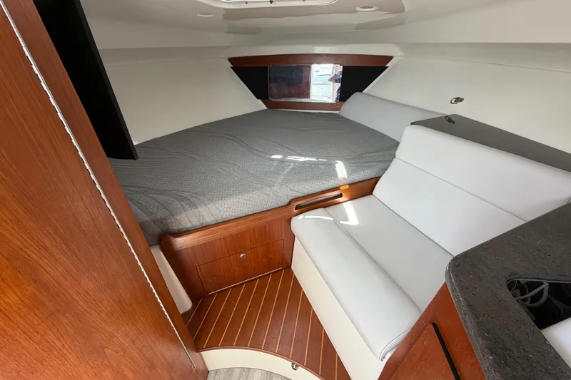Slide: The Image of 2009 Everglades 350LX cabin interior with bed, seating, and wood accents. - 54