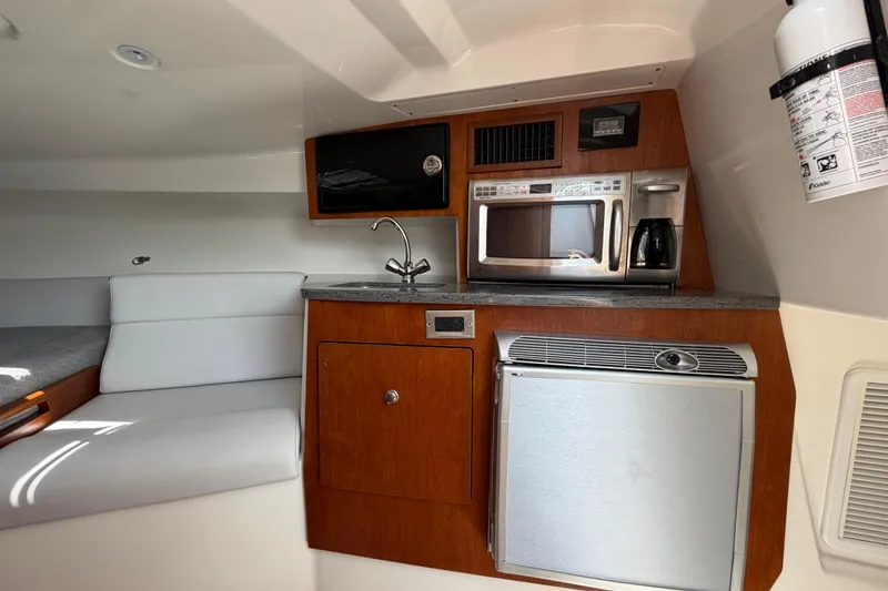 Slide: The Image of Compact kitchen area in a 2009 Everglades 350LX boat with modern appliances. - 57