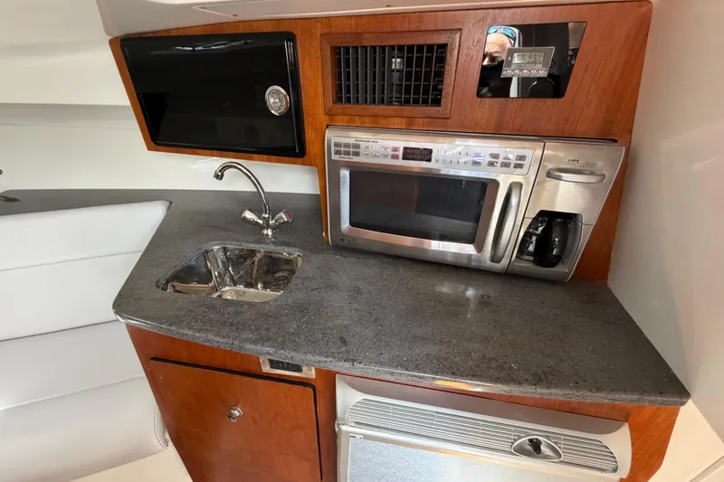 Slide: The Image of Compact kitchen area in a 2009 Everglades 350LX boat with sink and microwave. - 59