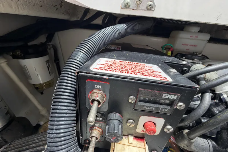 Slide: The Image of Control panel of a 2009 Everglades 350LX boat with warning label and hour meter. - 65